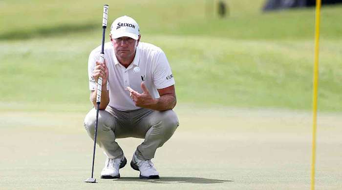 Lucas Glover catches a ball as he plans out his putt on the ninth hole during the second round of the 2023 FedEx St. Jude Championship at TPC Southwind in Memphis, Tenn.